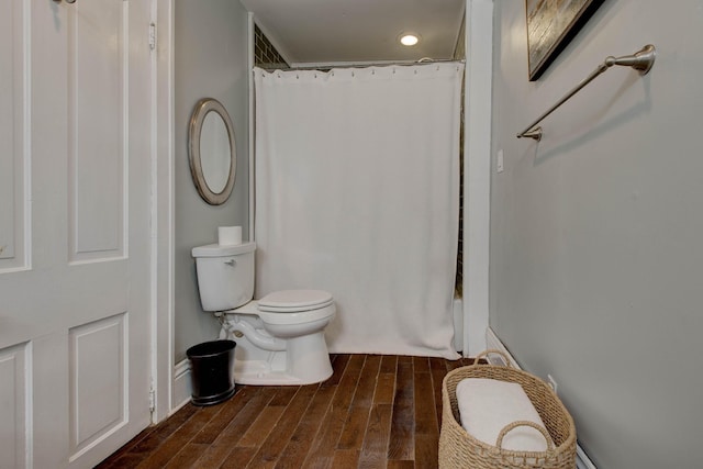 full bath with toilet, a shower with curtain, and wood finished floors