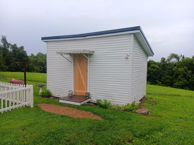 view of outdoor structure featuring fence and an outdoor structure