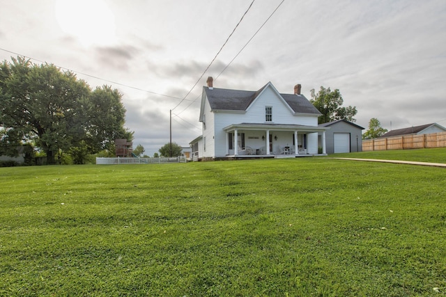 view of front facade with covered porch, a front lawn, fence, and a garage