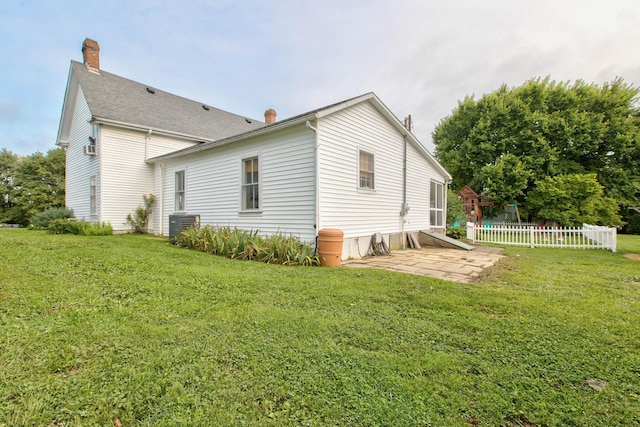 back of house with fence, a lawn, and a patio