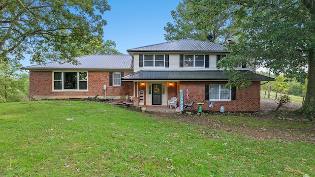 tri-level home featuring a porch, a front yard, metal roof, and brick siding