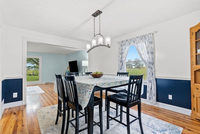 dining area featuring baseboards, a notable chandelier, and light wood-style floors