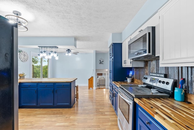 kitchen featuring a ceiling fan, butcher block countertops, blue cabinets, stainless steel appliances, and light wood-type flooring