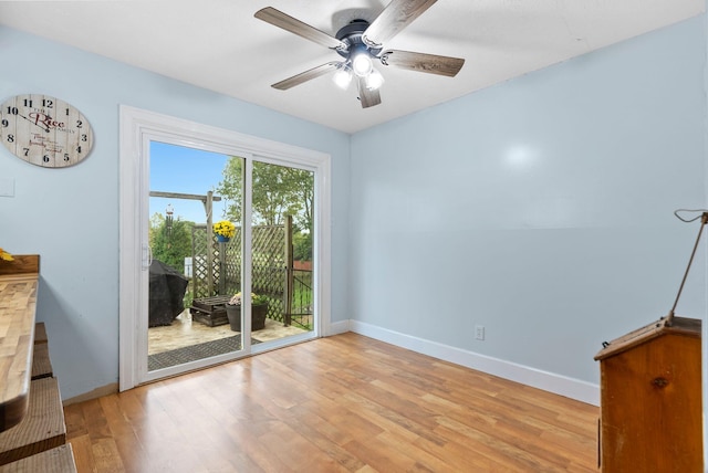 empty room featuring light wood-type flooring, ceiling fan, and baseboards