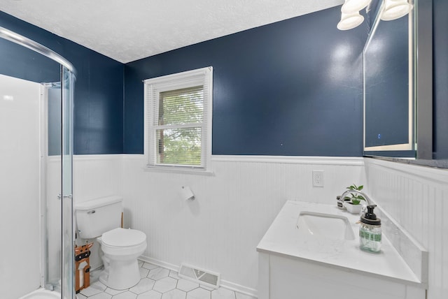 bathroom featuring a wainscoted wall, visible vents, a shower stall, and toilet