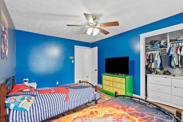 bedroom featuring a closet, ceiling fan, a textured ceiling, and wood finished floors