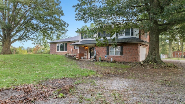 traditional-style house with a garage, metal roof, brick siding, and a front lawn