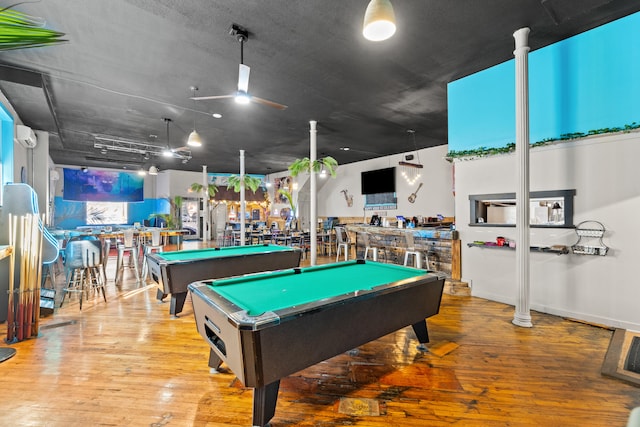 rec room with a community bar, an AC wall unit, pool table, and hardwood / wood-style flooring