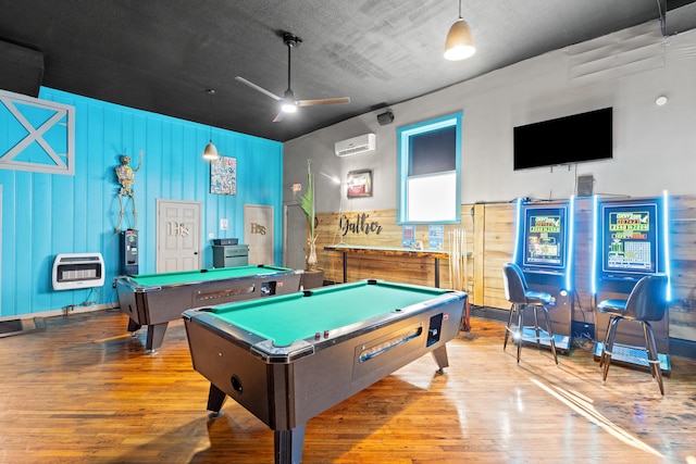 game room featuring a wall unit AC, billiards, light wood-style flooring, and heating unit