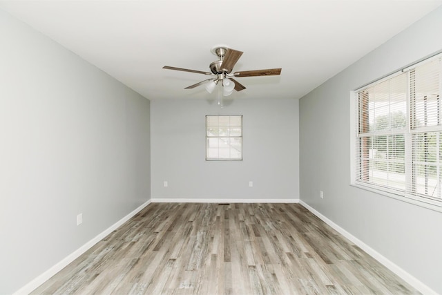 spare room with light wood finished floors, baseboards, and a ceiling fan