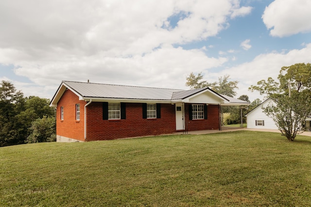 ranch-style house featuring brick siding, a front yard, and an attached carport