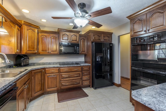 kitchen with black appliances, a textured ceiling, light tile patterned floors, and a sink