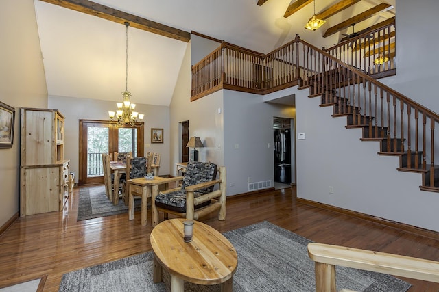 living room featuring stairs, baseboards, beam ceiling, and wood finished floors