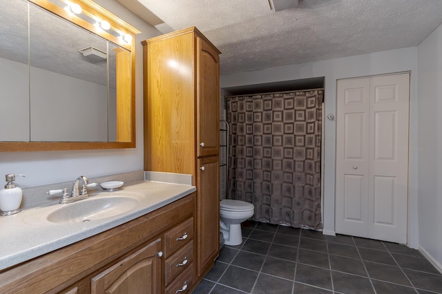 bathroom featuring toilet, tile patterned flooring, a textured ceiling, and vanity