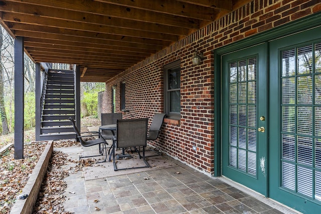 view of patio with stairs and outdoor dining area