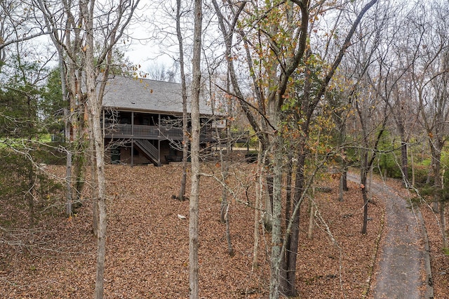 rear view of house featuring a wooden deck and stairs