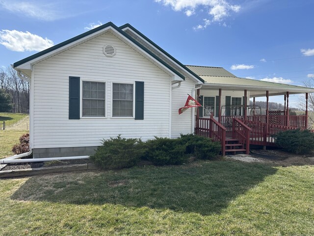 back of property with metal roof and a yard