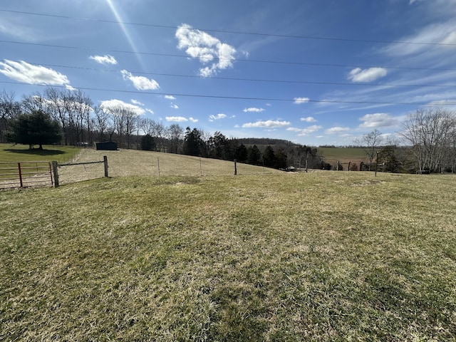 view of yard featuring fence and a rural view