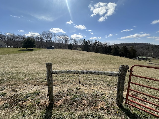 view of yard featuring fence and a rural view