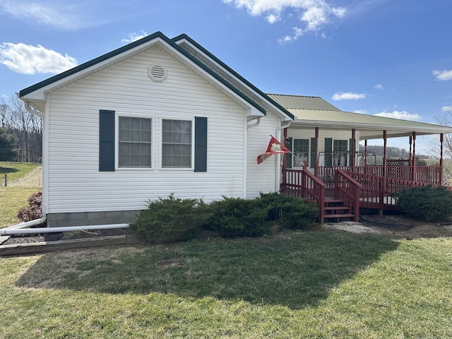 view of front facade featuring metal roof and a front yard