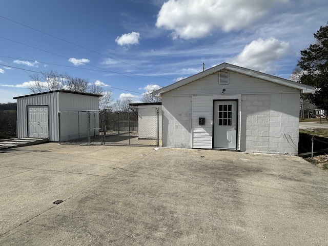 view of outdoor structure featuring a gate, fence, and an outdoor structure