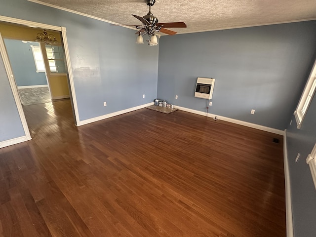 spare room with baseboards, a ceiling fan, wood finished floors, heating unit, and a textured ceiling