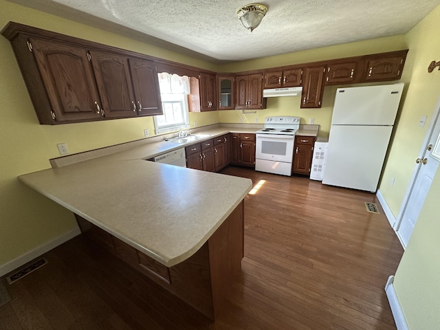 kitchen featuring a textured ceiling, under cabinet range hood, white appliances, dark wood-type flooring, and visible vents