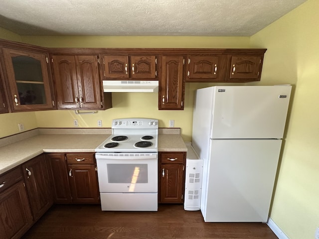 kitchen featuring white appliances, under cabinet range hood, light countertops, and dark wood finished floors