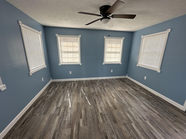 spare room featuring dark wood-style floors, baseboards, and a textured ceiling