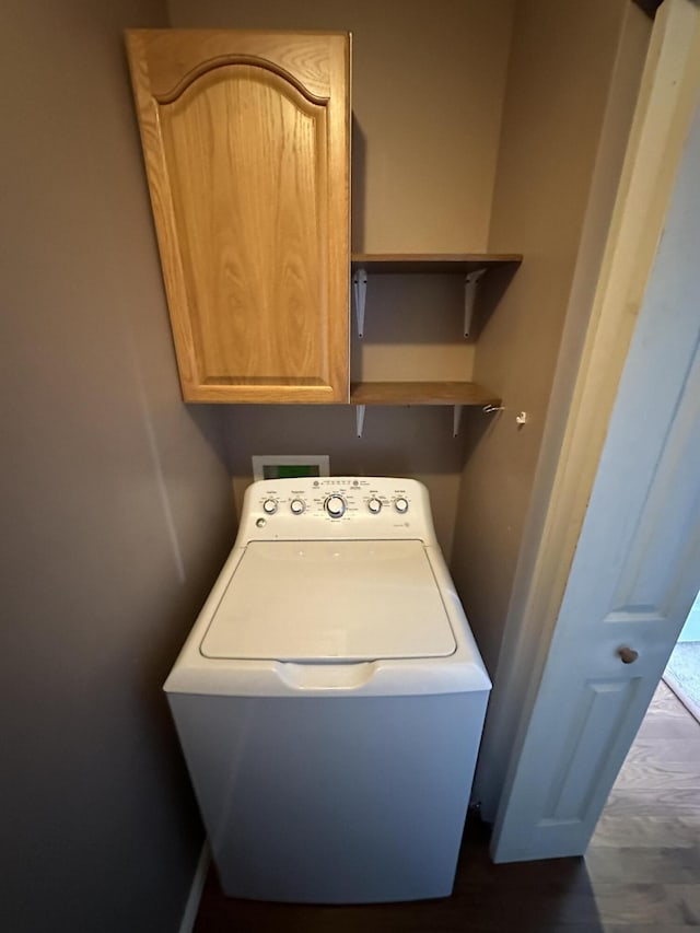 clothes washing area with washer / dryer and cabinet space