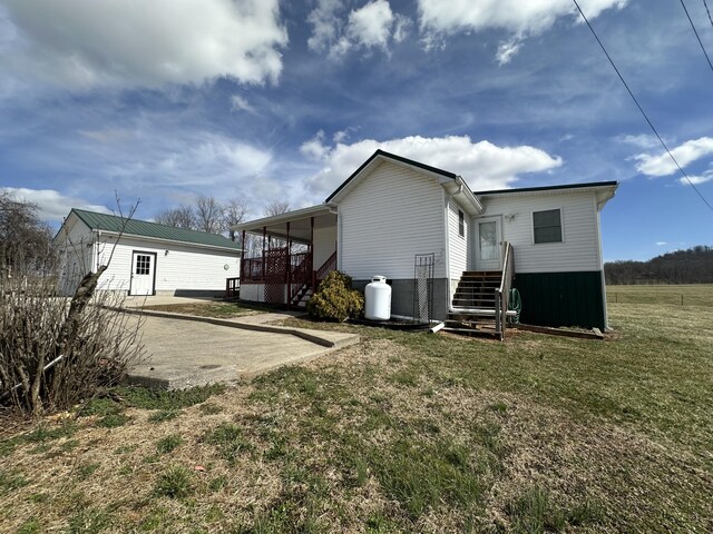 back of property featuring driveway and a yard