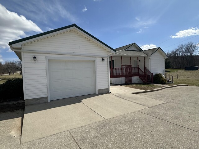 view of front of property with a garage, a porch, and concrete driveway