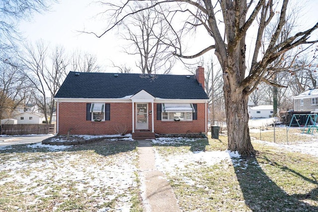 bungalow with brick siding, fence, and a chimney