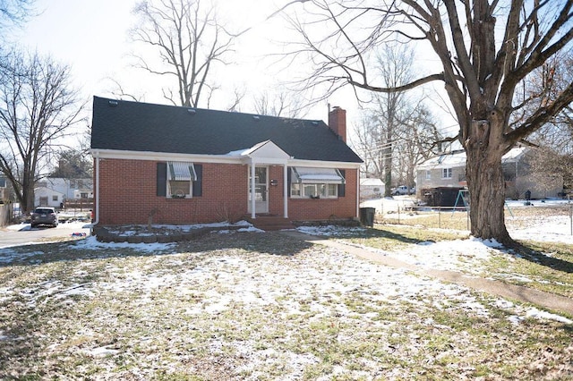 view of front facade featuring brick siding and a chimney