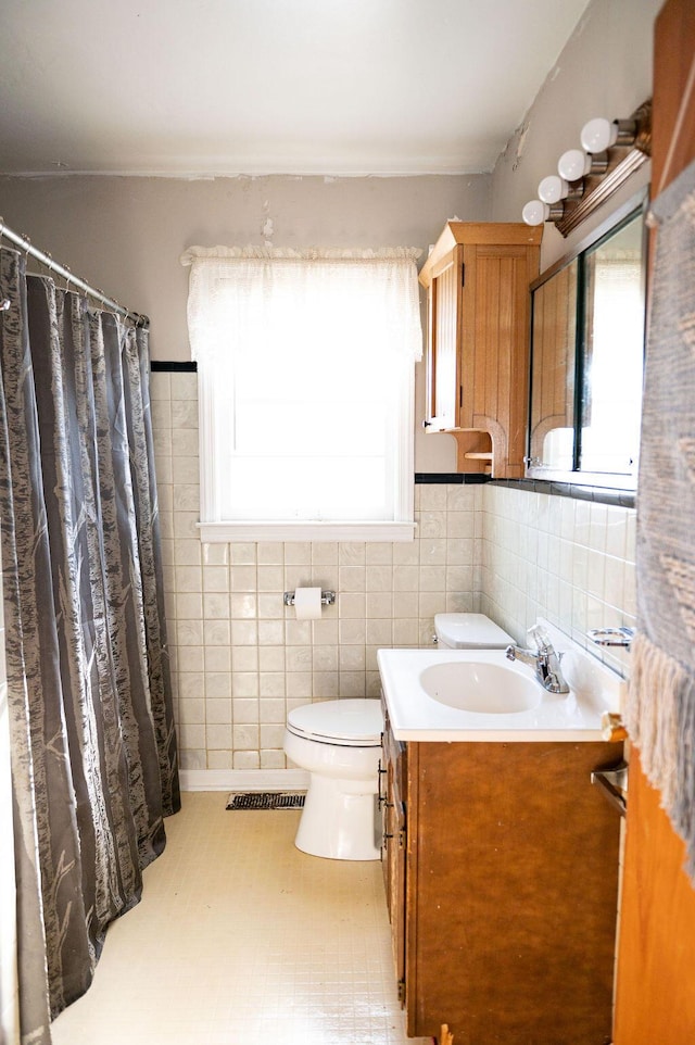 bathroom with visible vents, toilet, a shower with curtain, vanity, and tile walls