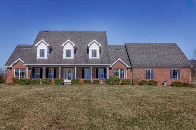 new england style home featuring a front lawn and brick siding