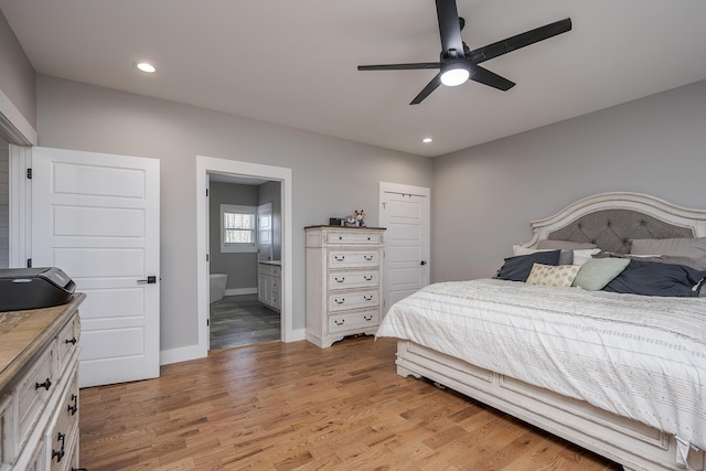 bedroom with baseboards, ceiling fan, light wood-type flooring, recessed lighting, and ensuite bath