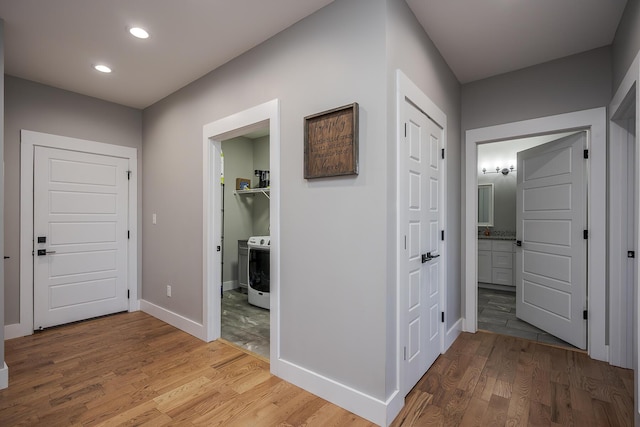 hallway with recessed lighting, baseboards, light wood-style floors, and washer / dryer