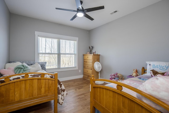 bedroom with visible vents, a ceiling fan, light wood-type flooring, and baseboards