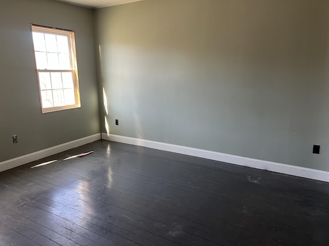 unfurnished room featuring dark wood-style floors and baseboards