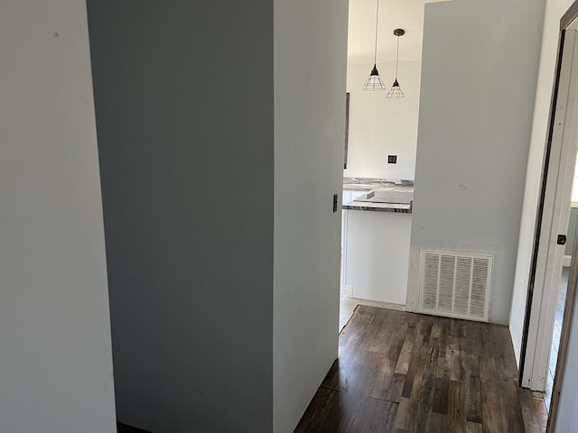 corridor with visible vents and dark wood-type flooring