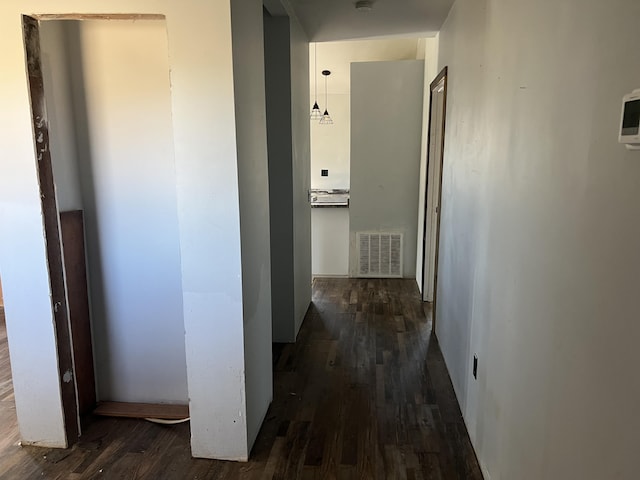 hallway with dark wood-type flooring and visible vents