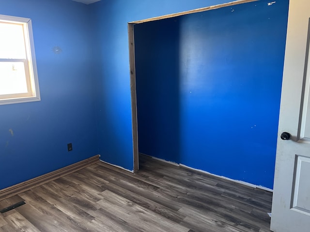 unfurnished room featuring dark wood finished floors and baseboards