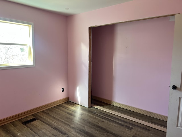 empty room with visible vents, baseboards, and wood finished floors