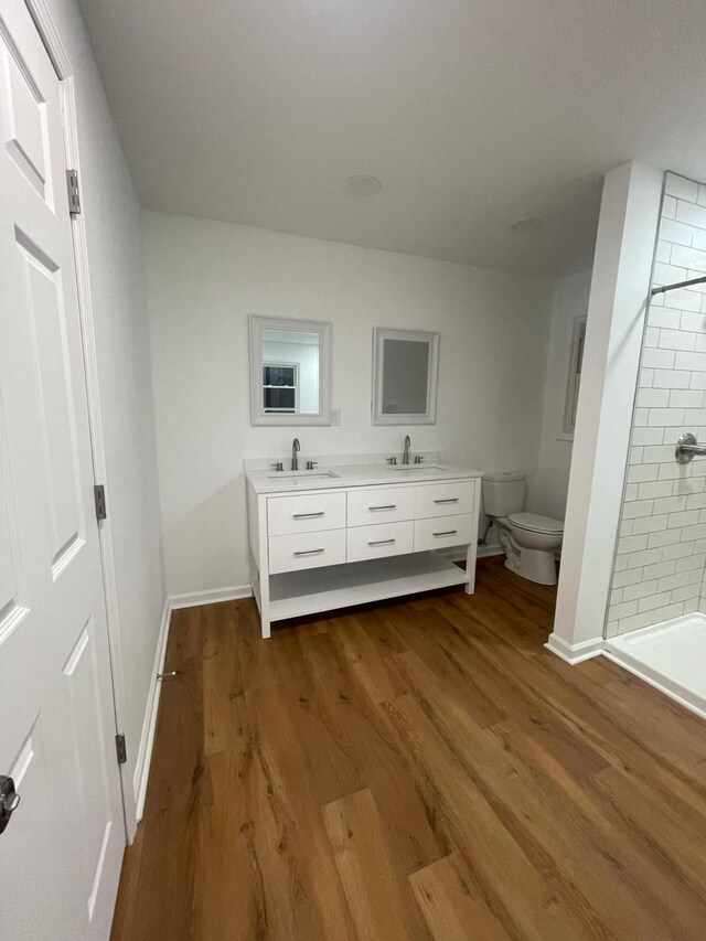 unfurnished bedroom with a sink, baseboards, and wood finished floors