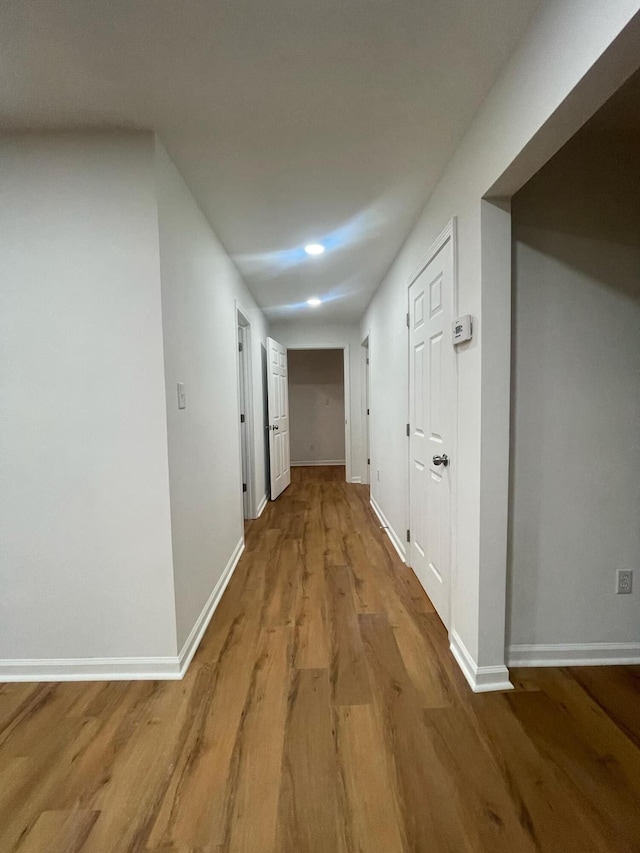 hallway featuring baseboards and light wood-style floors