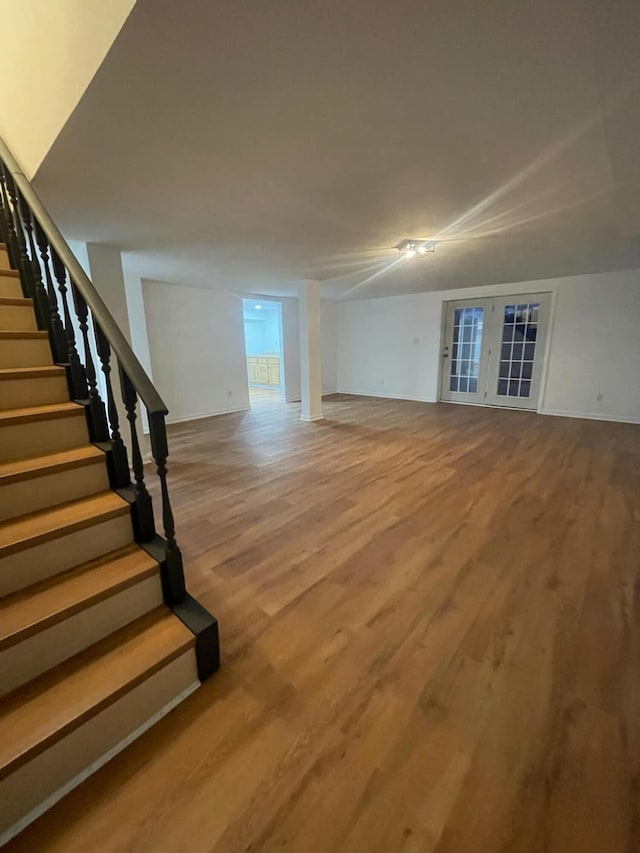 unfurnished living room with stairs and wood finished floors