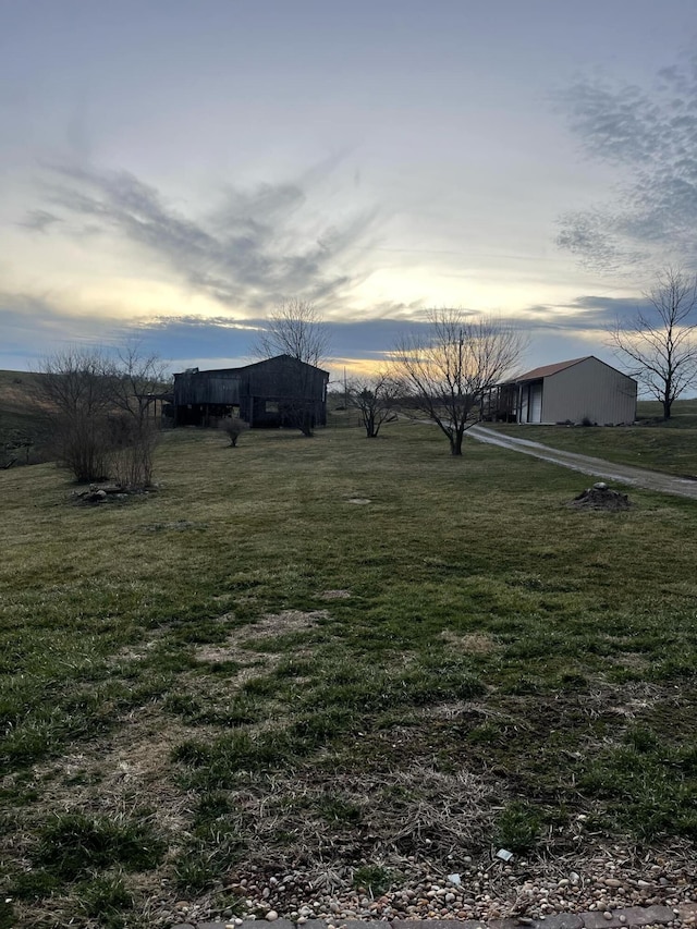 yard at dusk with an outbuilding and a rural view