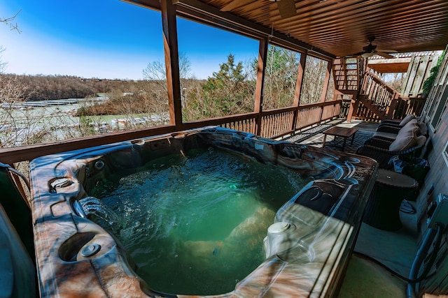 exterior space with a ceiling fan, stairway, a wooden deck, a wooded view, and a hot tub