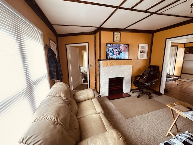 living room with a brick fireplace and crown molding